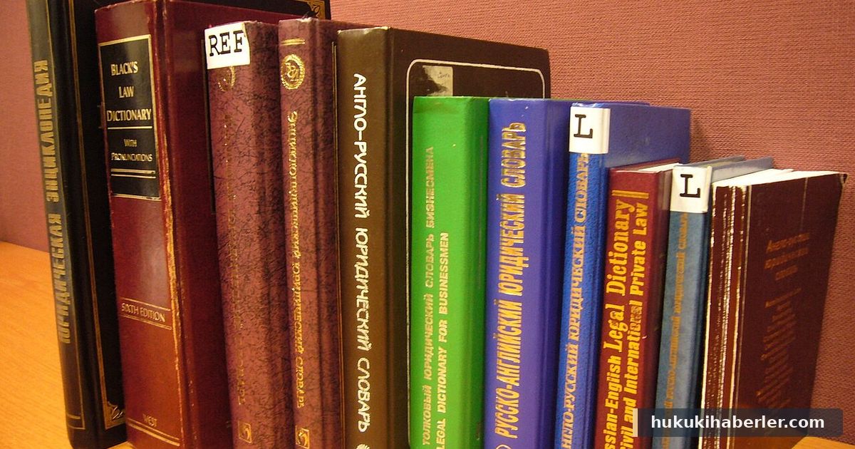 Ahşap rafta yan yana dizilmiş çeşitli renklerde kalın hukuk sözlükleri