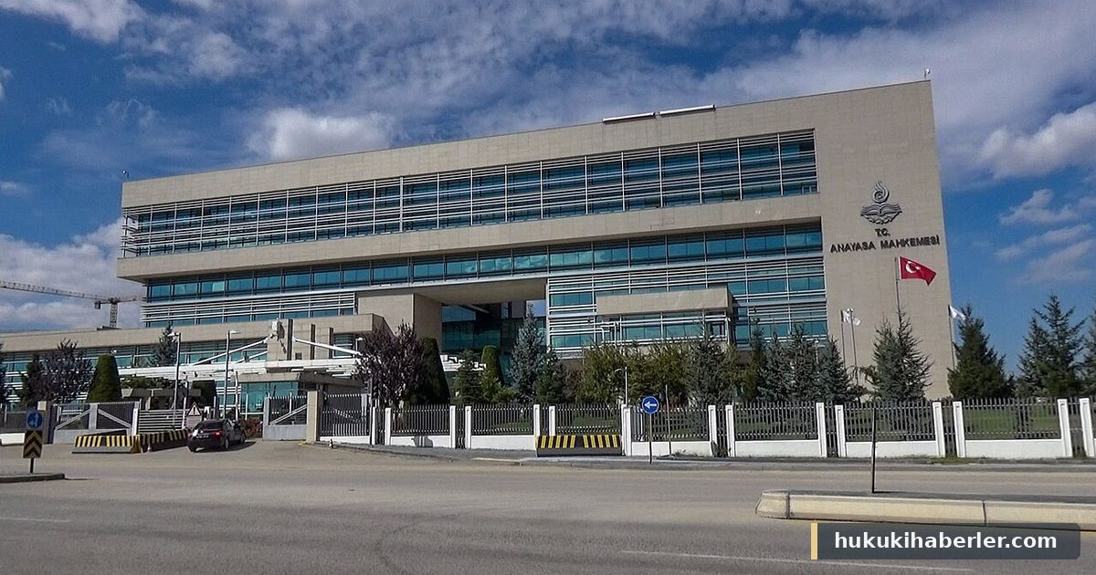 Türk bayraklı, camlı cepheli beton bir kamu binası ve önündeki bariyerli giriş