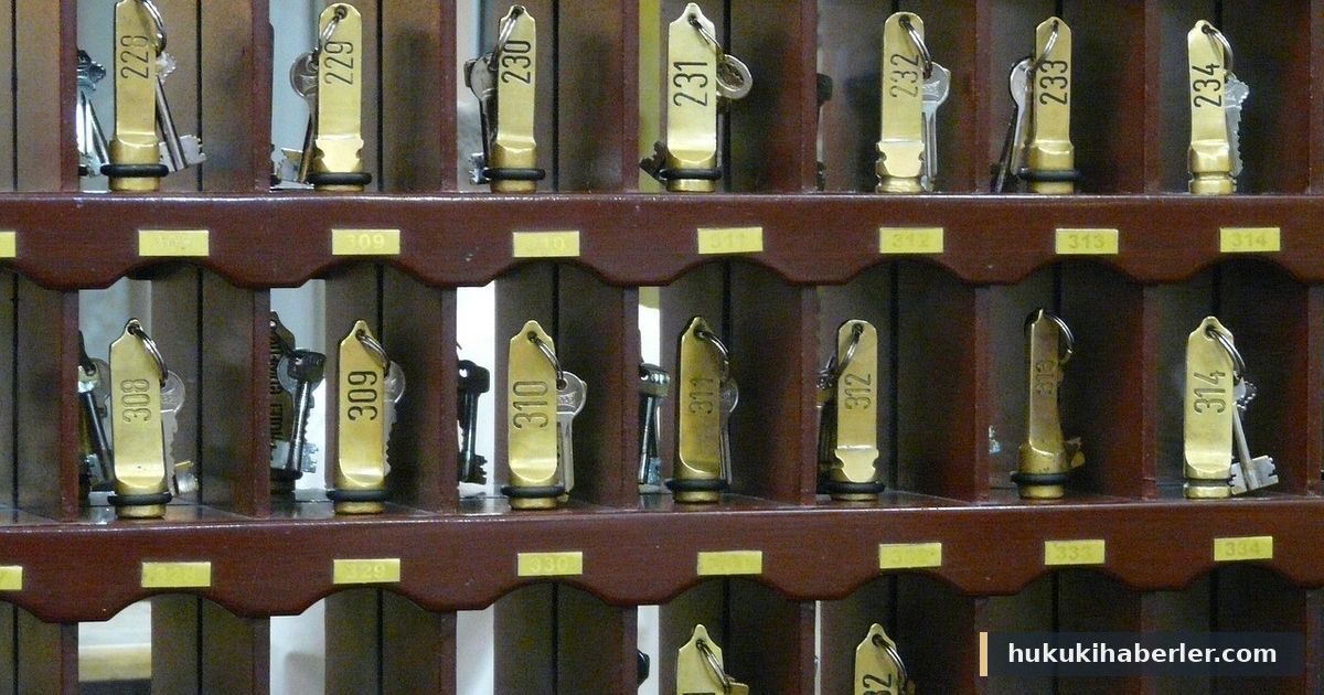 Numaralı pirinç anahtarlıkların asılı olduğu ahşap otel anahtar dolabı