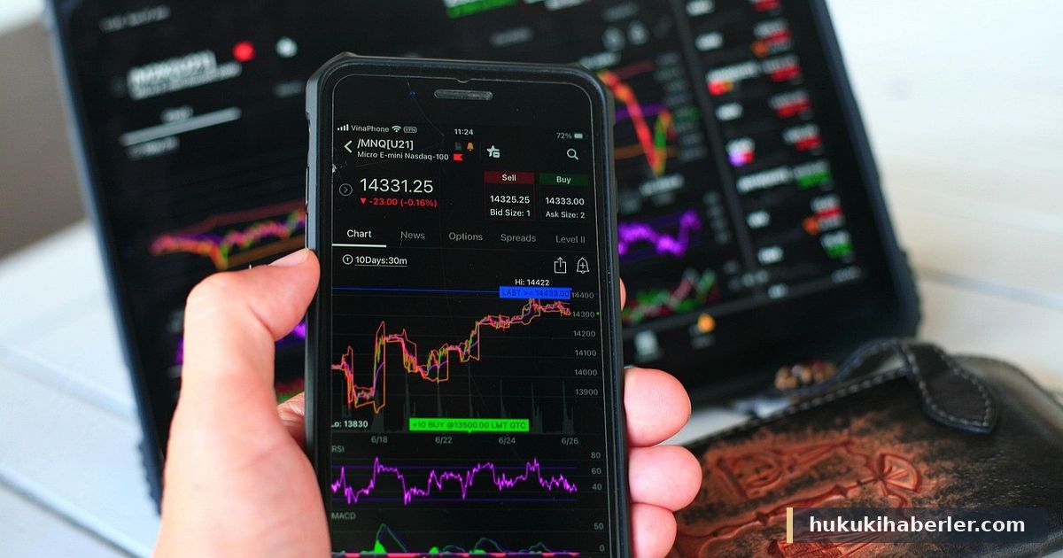 Akıllı telefonda finansal grafikler ve borsa verilerini inceleyen kişinin eli