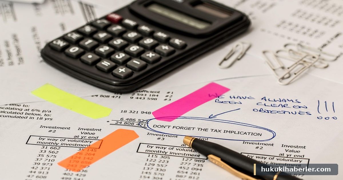 Hesap makinesi, kalem ve üzerinde vergi notu bulunan finansal tablolar masada