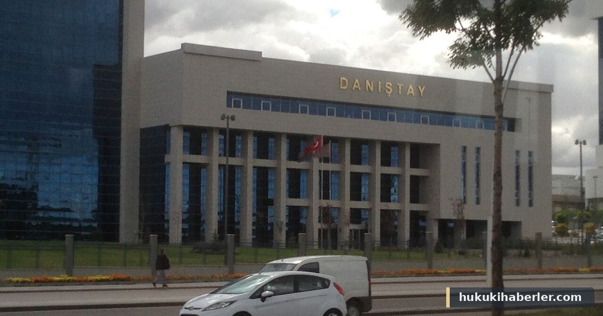 Üzerinde DANIŞTAY yazan, bayraklı beyaz kurum binası ve önünden geçen araçlar