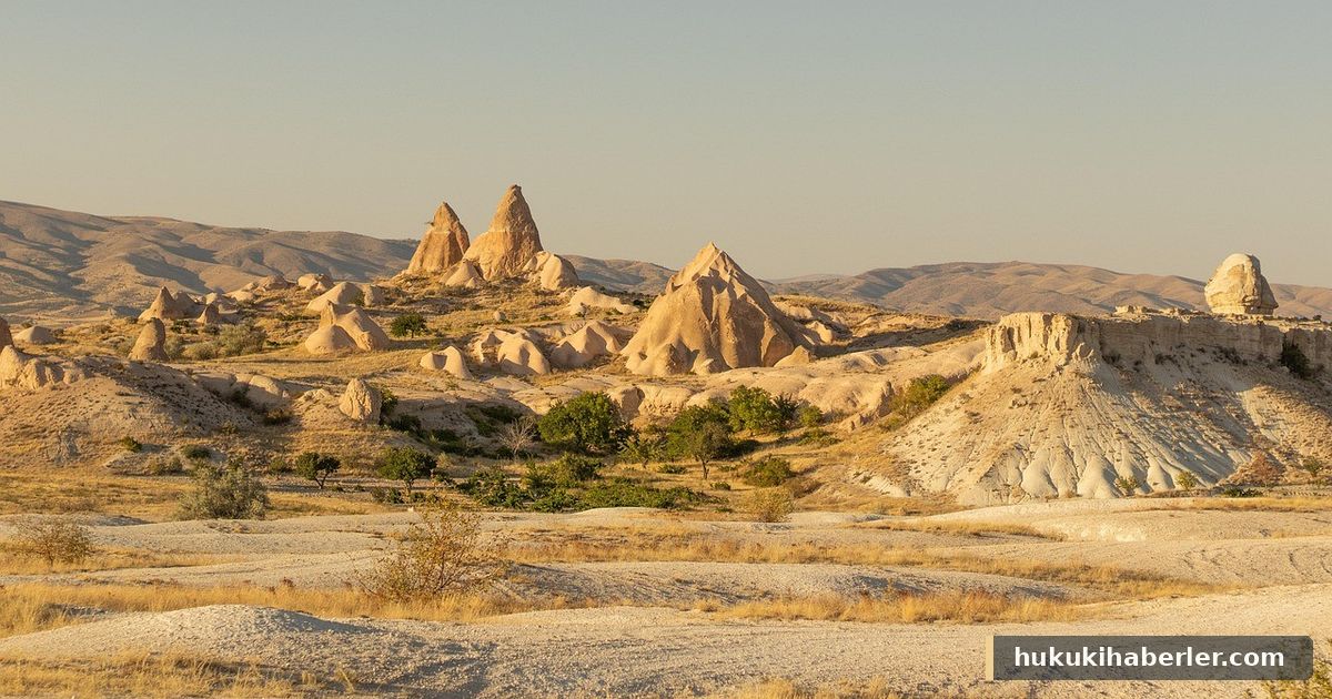 Güneş ışığında Göreme'de sivri peribacaları ve kurak yamaçlar