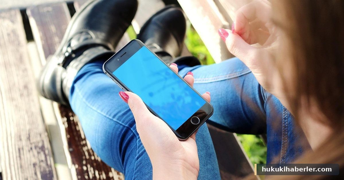 Mavi ekranlı akıllı telefonu tutan genç bir kadın, bankta oturmuş halde