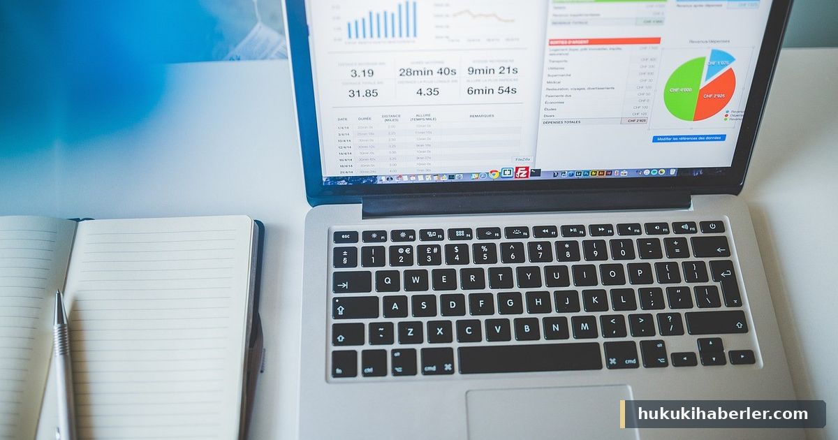 Dizüstü bilgisayar ekranında finansal grafikler ve bütçe tabloları, yanında açık not defteri