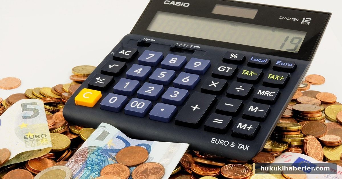 Siyah renkli masaüstü hesap makinesi ile etrafına saçılmış bozuk ve kağıt paralar